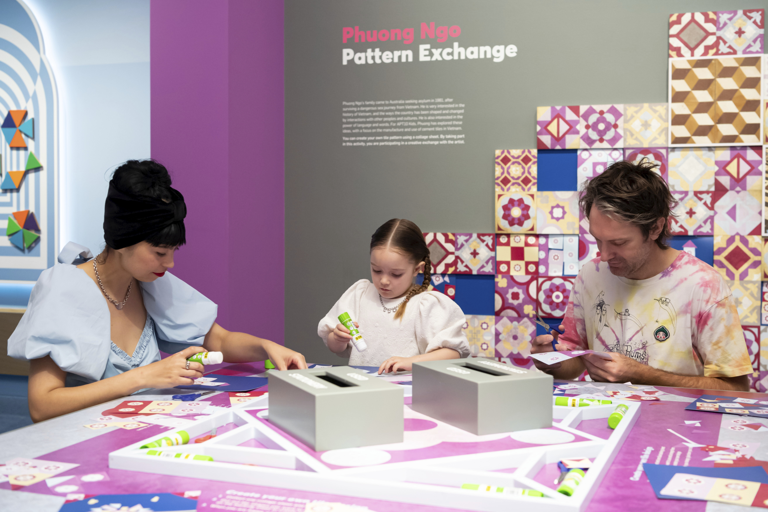 3 people sitting at a table and assembling patterns as part of APT10 Kids On Tour
