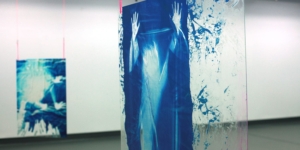 Two clear perspex panels with blue paint hang from the ceiling.