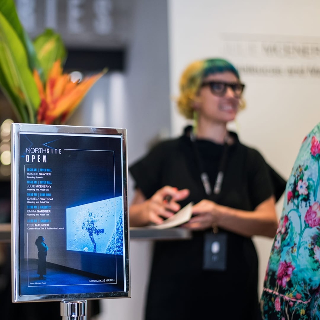 A image of a poster that contains the text 'NorthSite Open' a person is in the background.