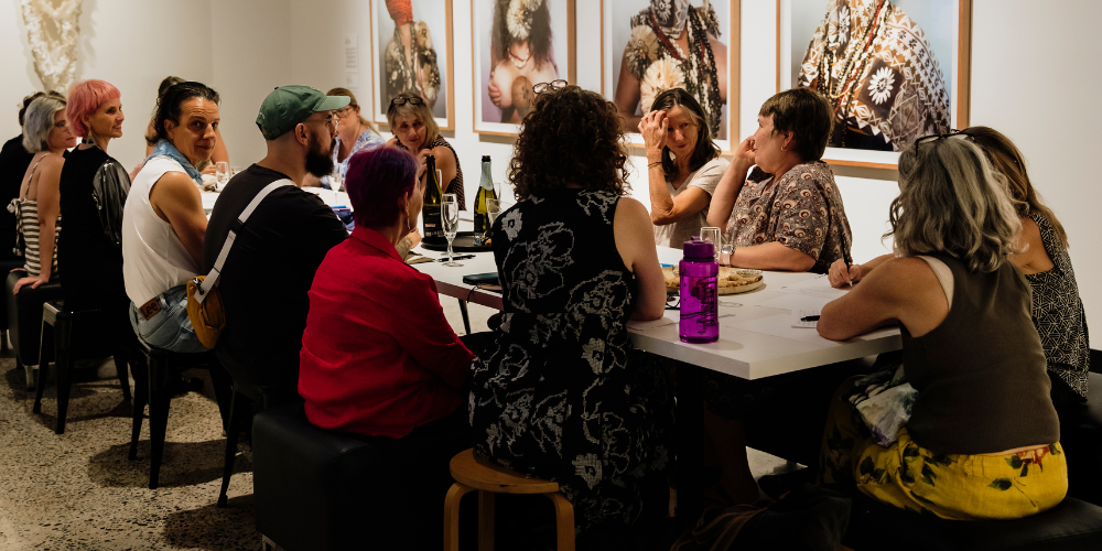 Artist Connect Program - people sitting around a table in a gallery room